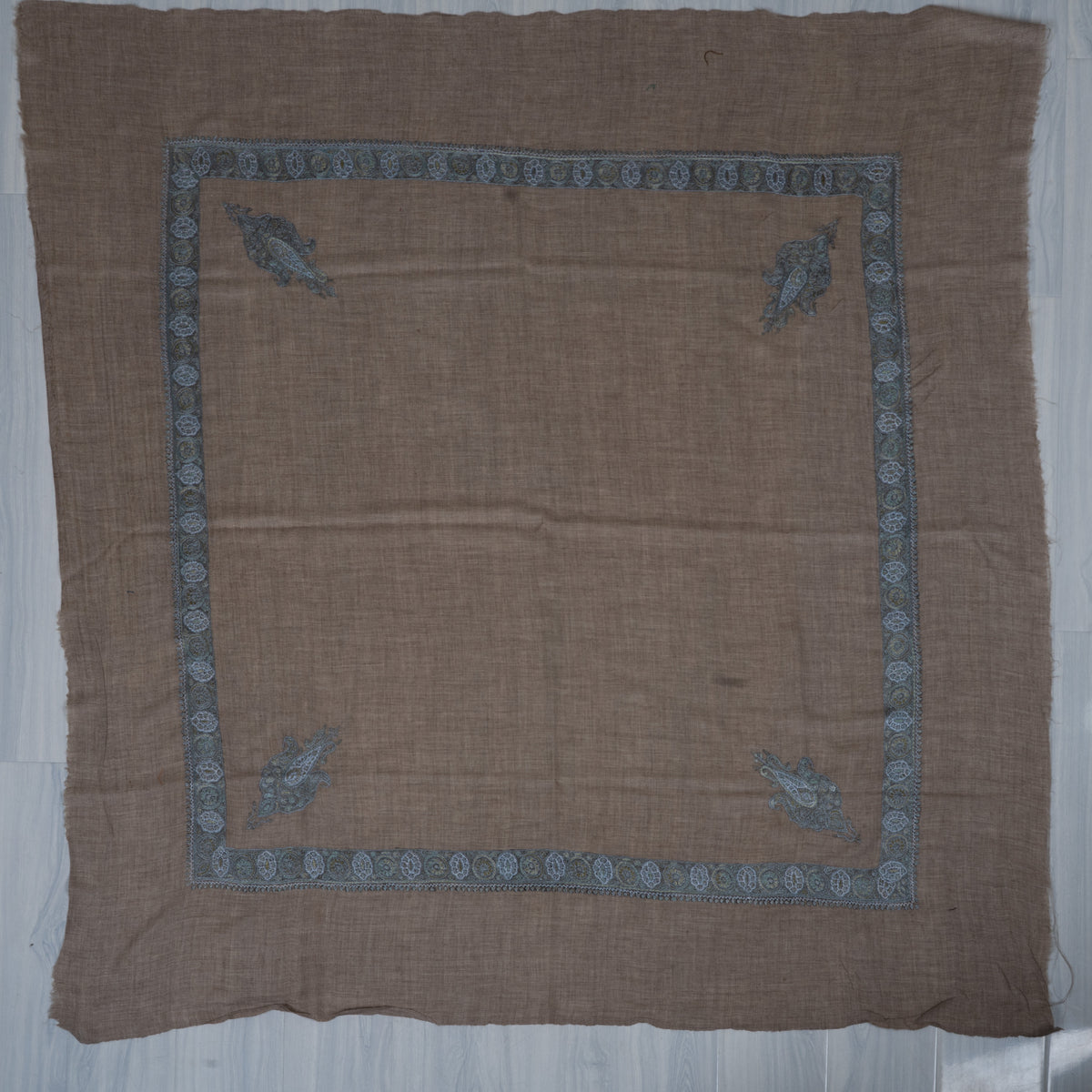 Mushroom-brown square cashmere rumal laid flat with blue-grey Sozni medallion borders, four paisleys and a plain centre.