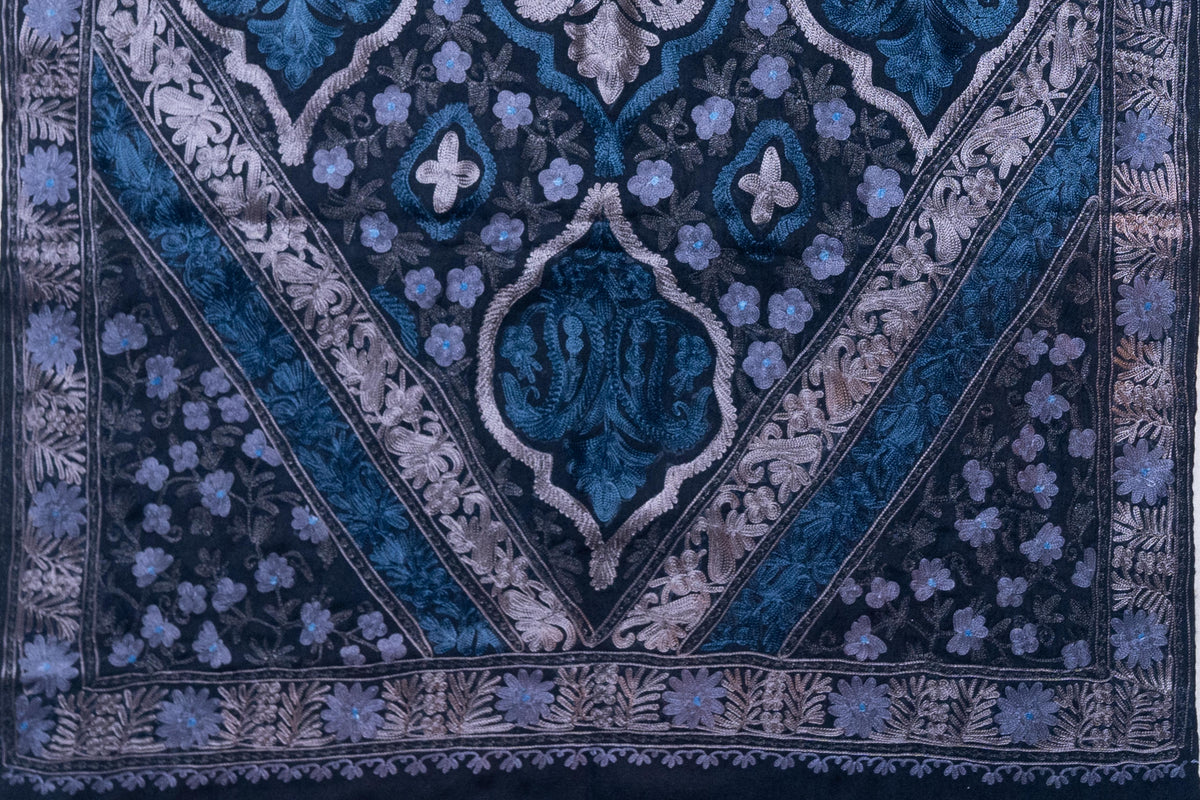 Black stole laid flat showing blue and silver-toned medallions framed by diagonal embroidered bands