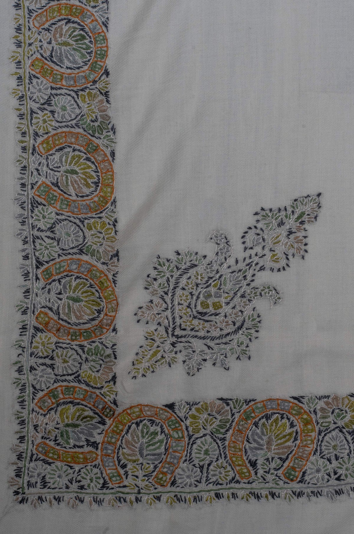 Ivory rumal corner with a separate olive and charcoal Sozni floral motif beside a broad gold-accented paisley border