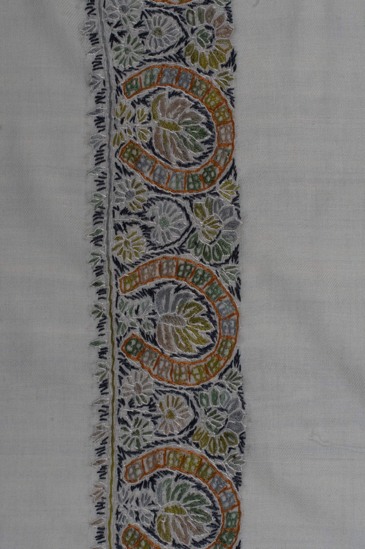 Close-up of a rumal border with gold-accented curling paisleys, olive flowers and charcoal details outlined in ivory