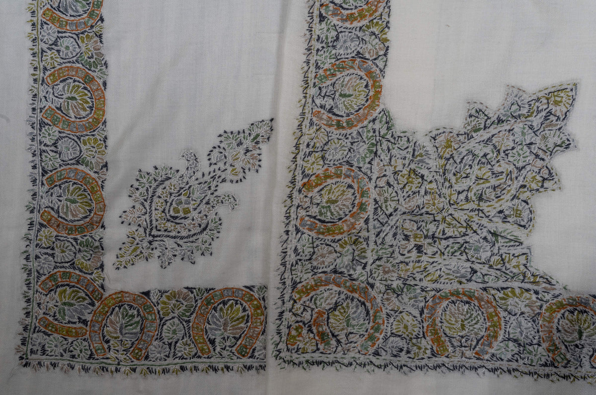 Overlapping ivory rumal corners showing olive, gold and charcoal Sozni borders and two differently shaped floral motifs