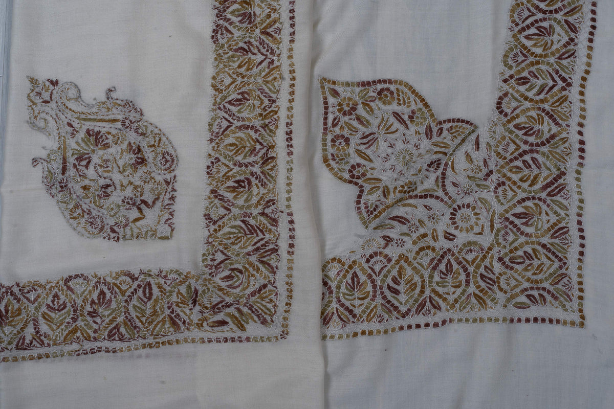 Two ivory Merino wool rumal corners comparing a separate Sozni floral motif with a larger leaf motif joined to the border.