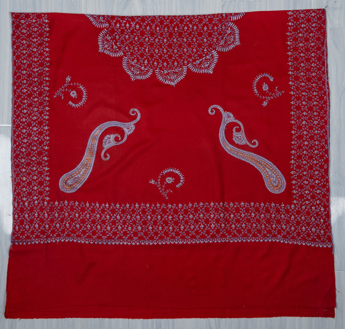 Ruby-red shawl spread flat with pale Sozni paisleys, curved floral sprigs and wide lattice borders
