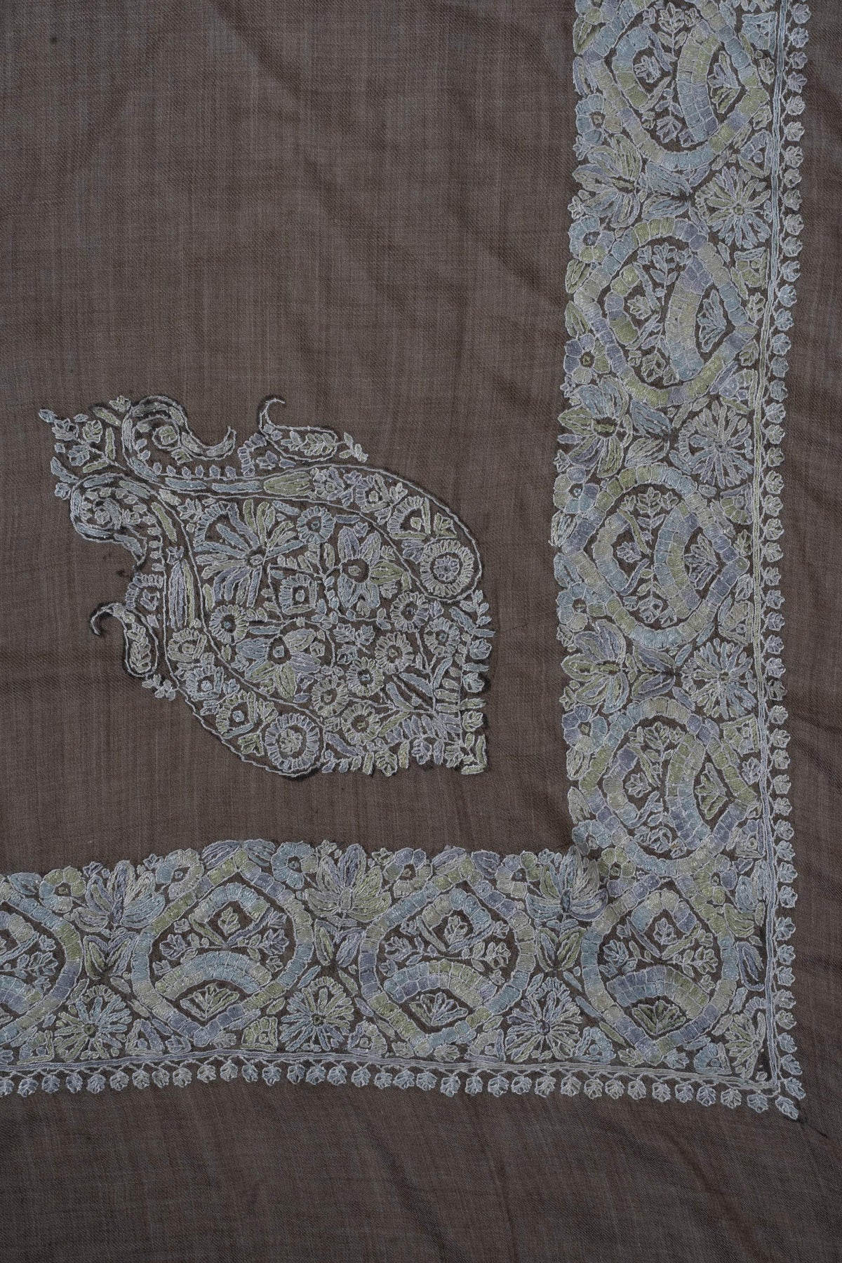 Taupe rumal corner with a separate pale blue-grey Sozni floral crest inside a broad embroidered border