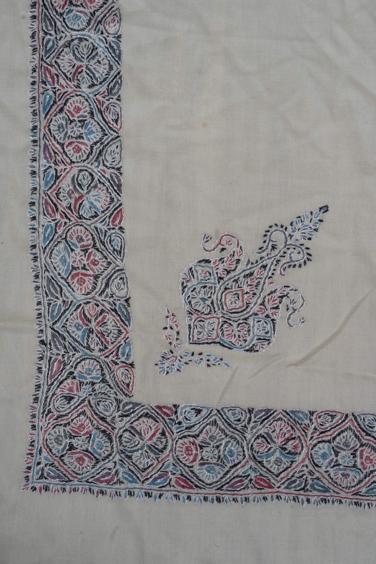 Ivory rumal corner with a blue and pink floral border and a smaller ornamental motif