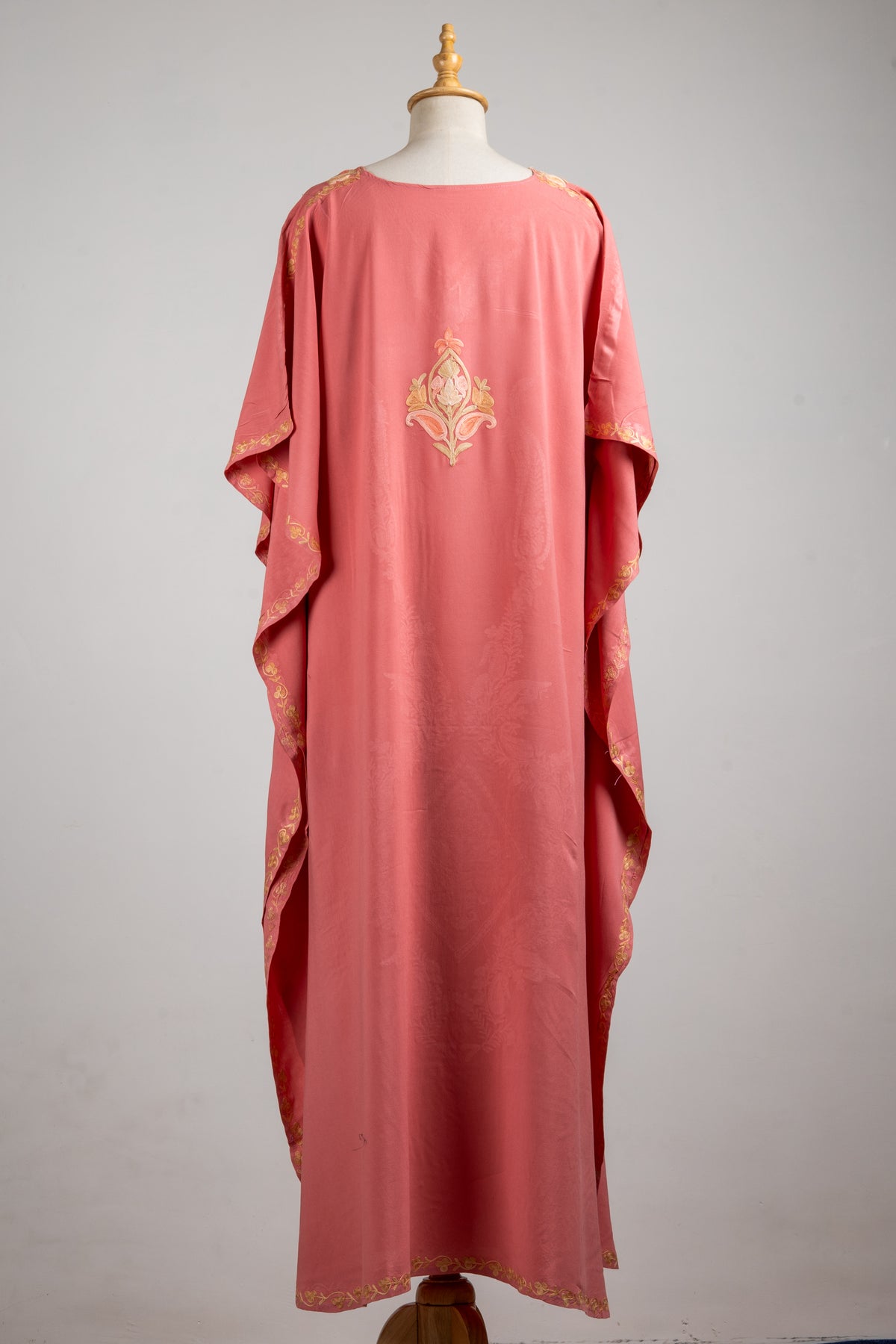 Back of the blush-rose kaftan, with a small champagne floral motif and narrow embroidery along the sleeve edges
