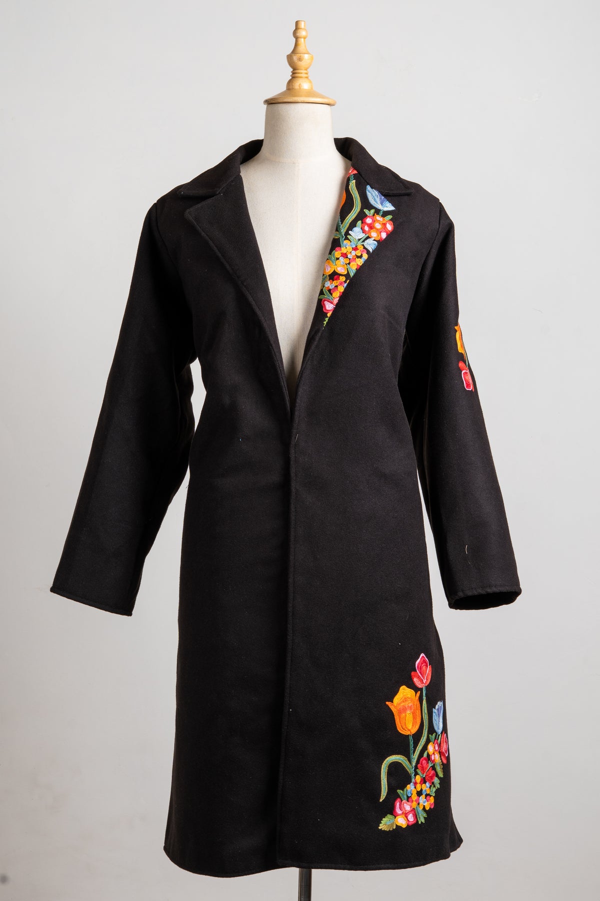 Full front view of the black longline blazer with floral accents on one lapel, one sleeve and the lower front.