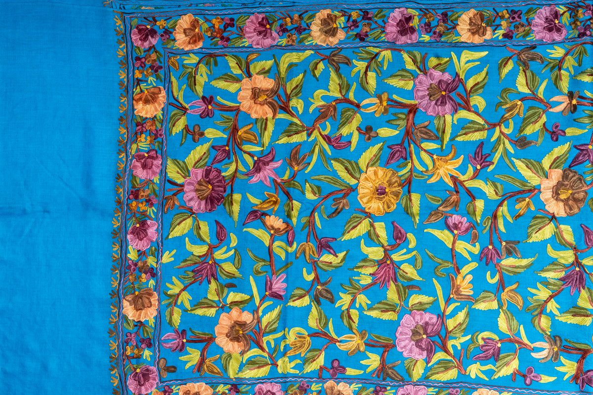 Peacock-blue stole laid flat, with lavender and mustard flowers, green leafy vines and a matching floral border