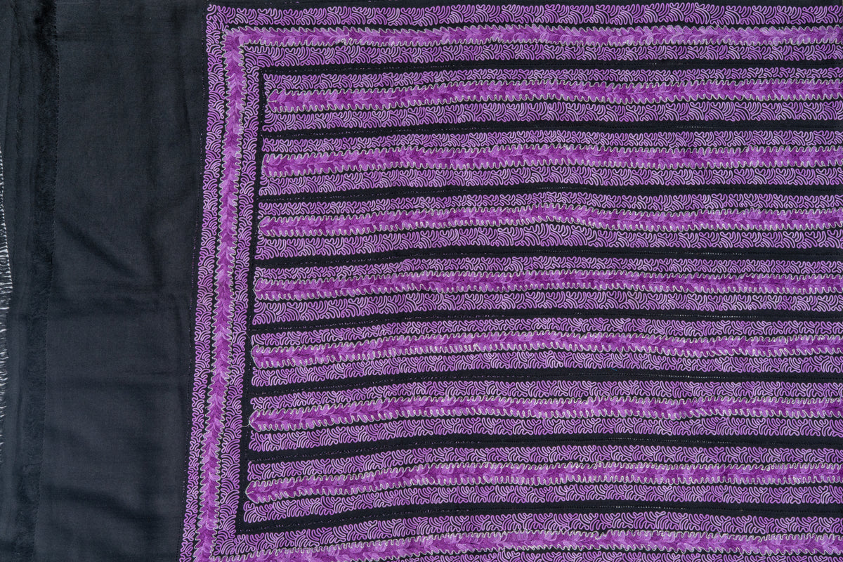 Flat view of the stole end with closely spaced purple embroidered rows framed by narrow lilac borders beside plain dark fabric.
