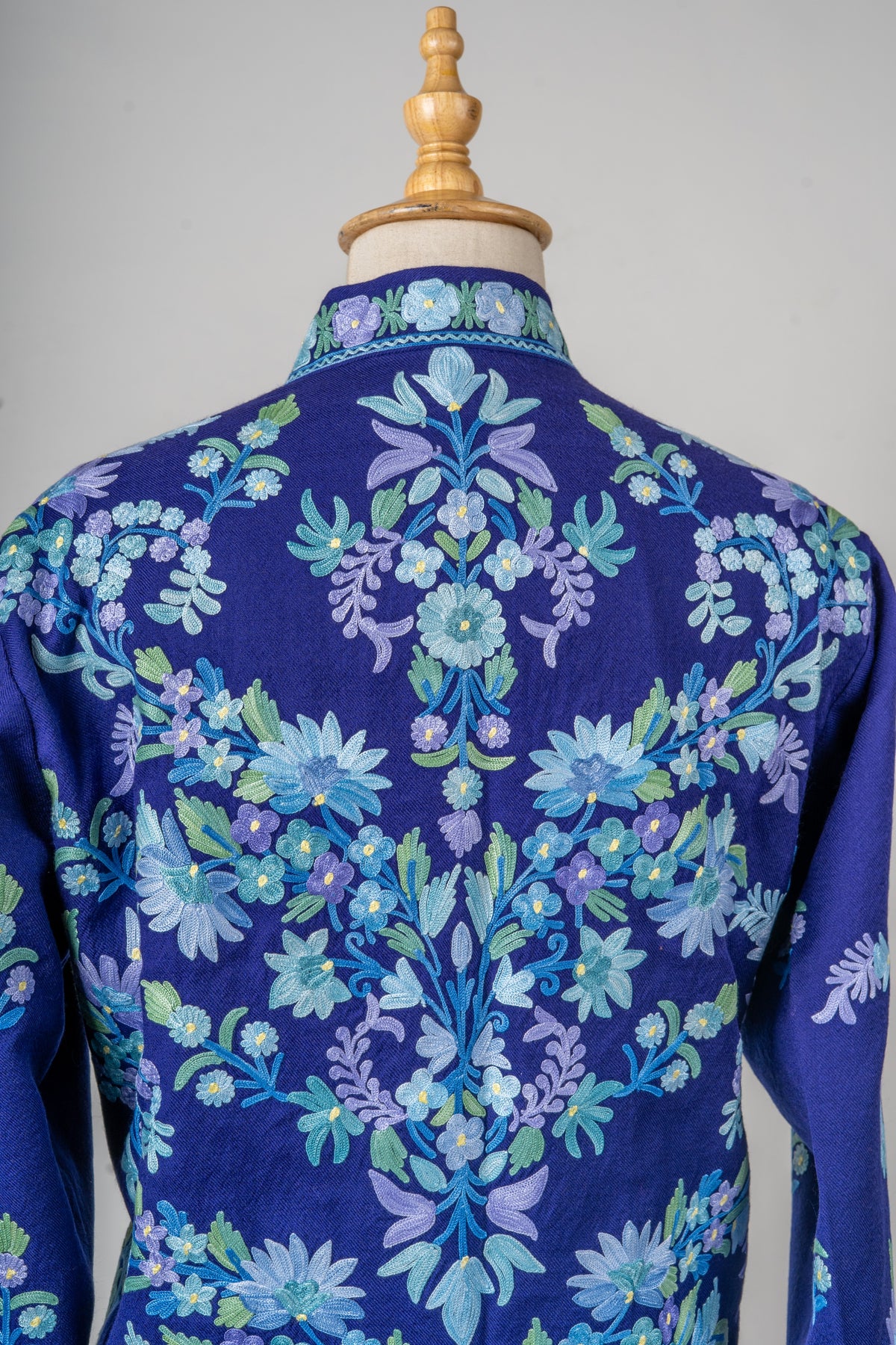 Close view of the indigo jacket’s back, showing mirrored floral sprays in blue, lavender and mint