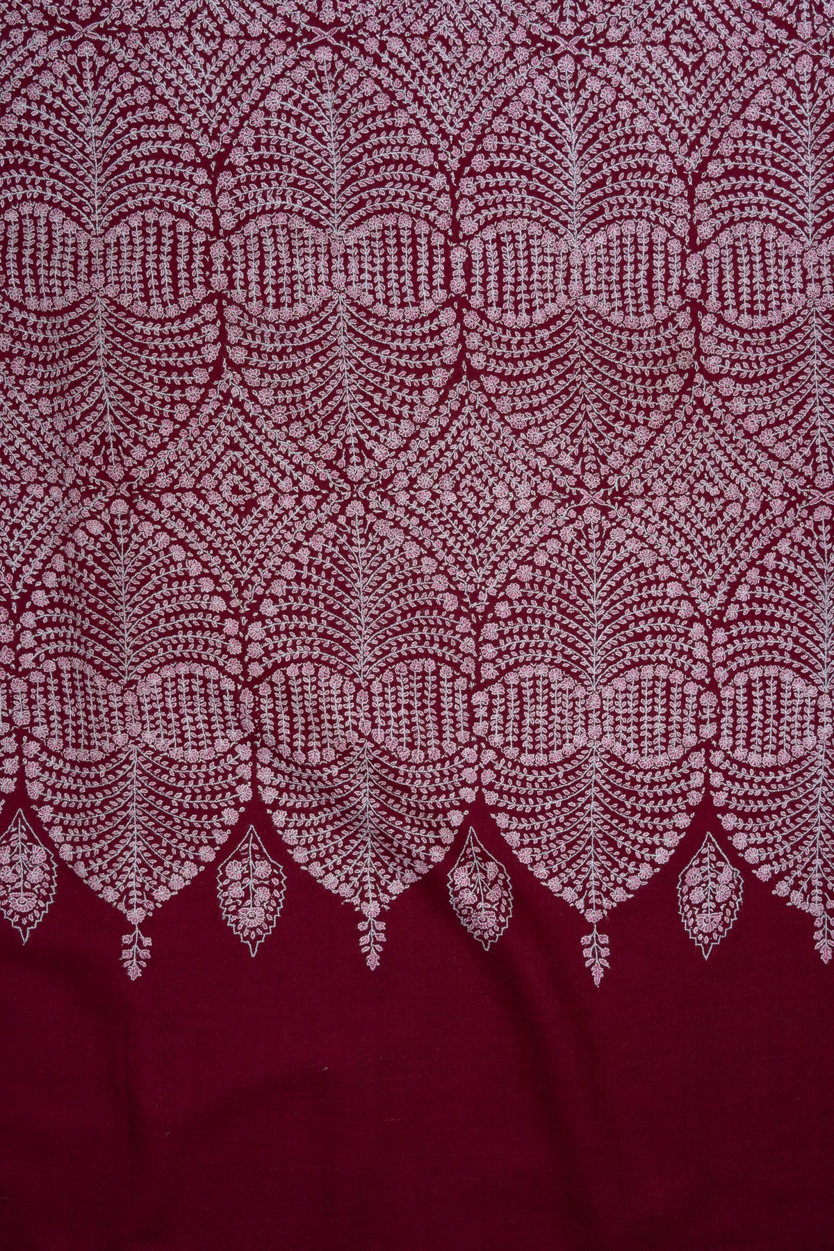 Flat detail of pale Sozni flowers forming curved bands and diamond centres on the deep wine Pashmina shawl