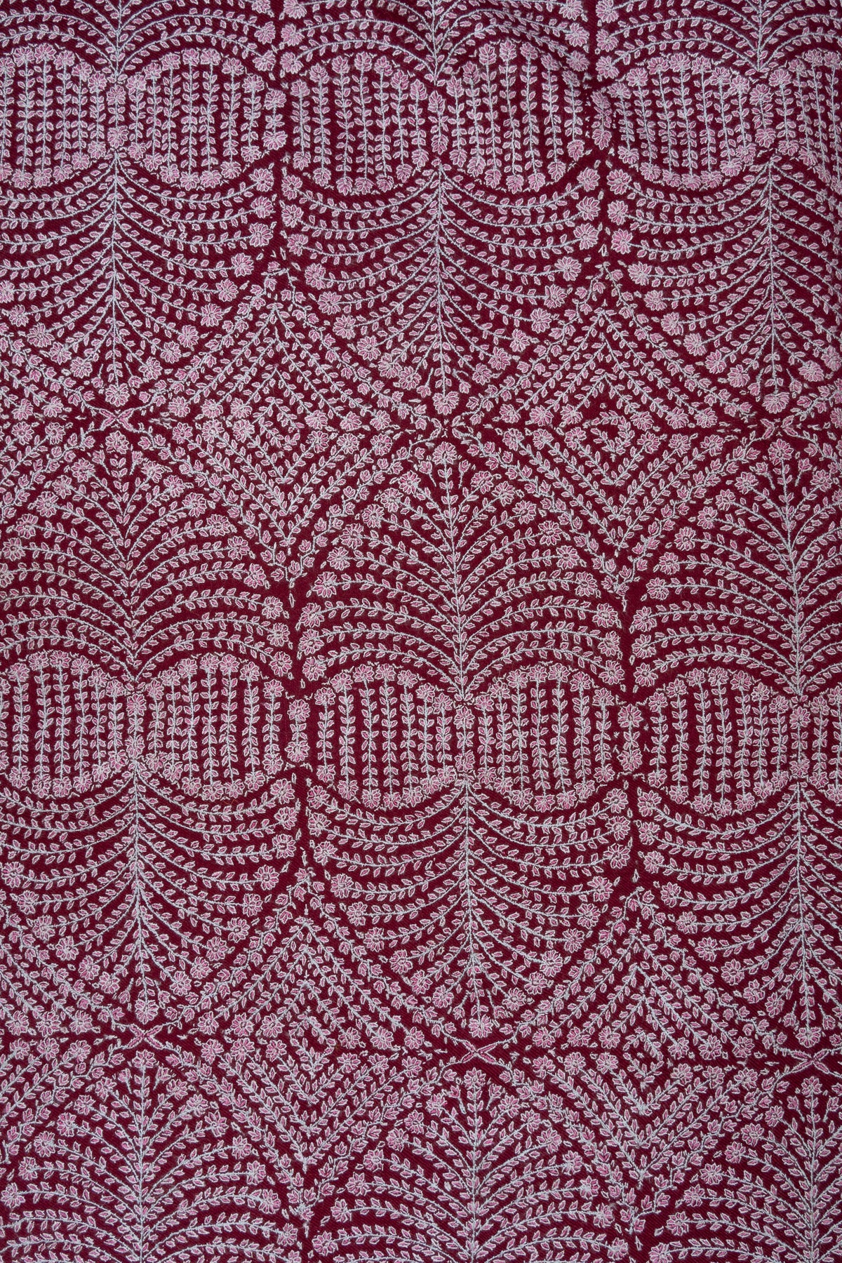Close view of the wine shawl's dense pale circular floral pattern, with fine rows of tiny embroidered leaves and flowers