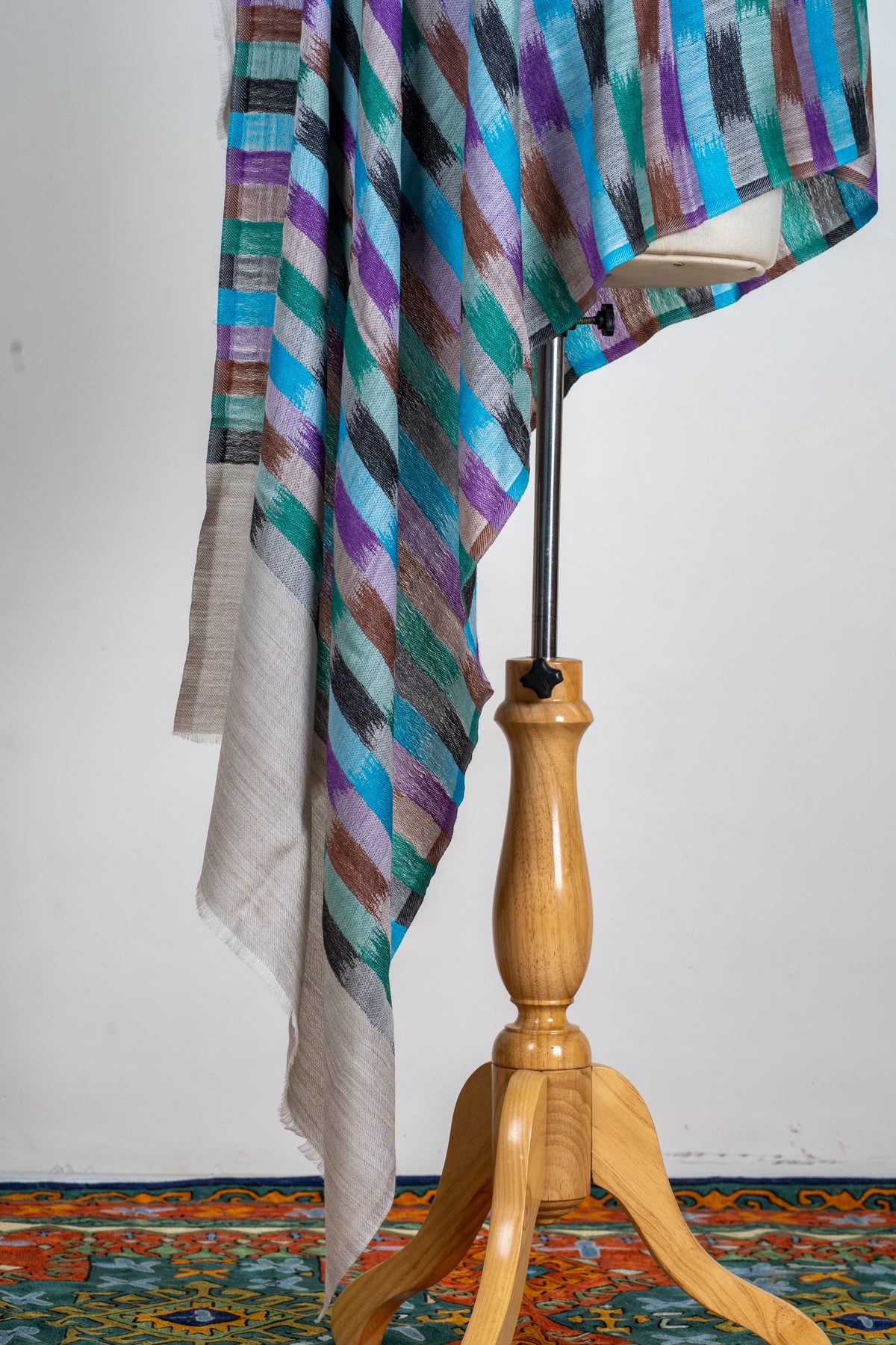 Hanging stole ends showing colourful rows of rectangular marks above a broad plain light-grey panel.
