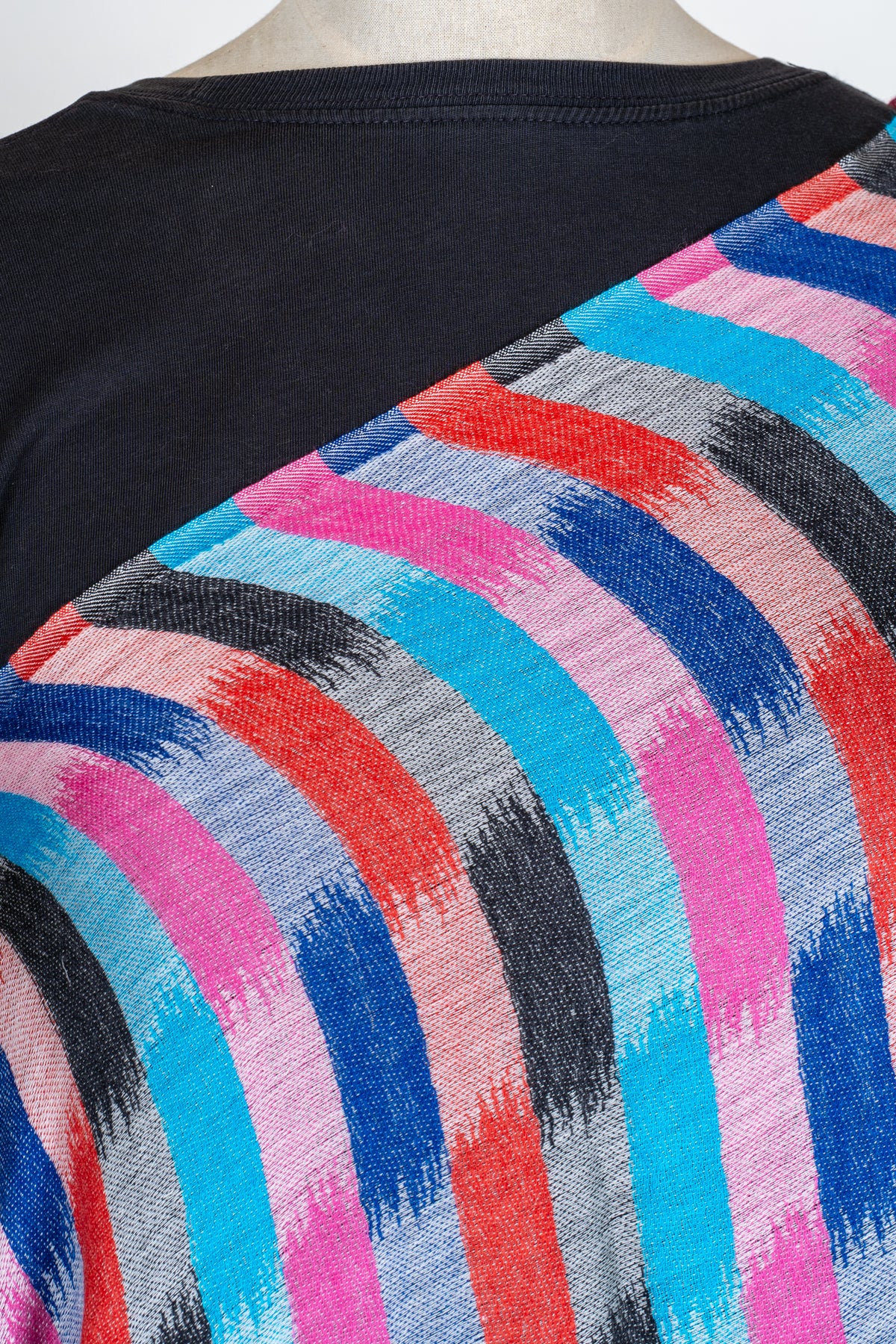 Close view of turquoise, pink, red, blue and black brushstroke checks on the stole’s fine woven surface