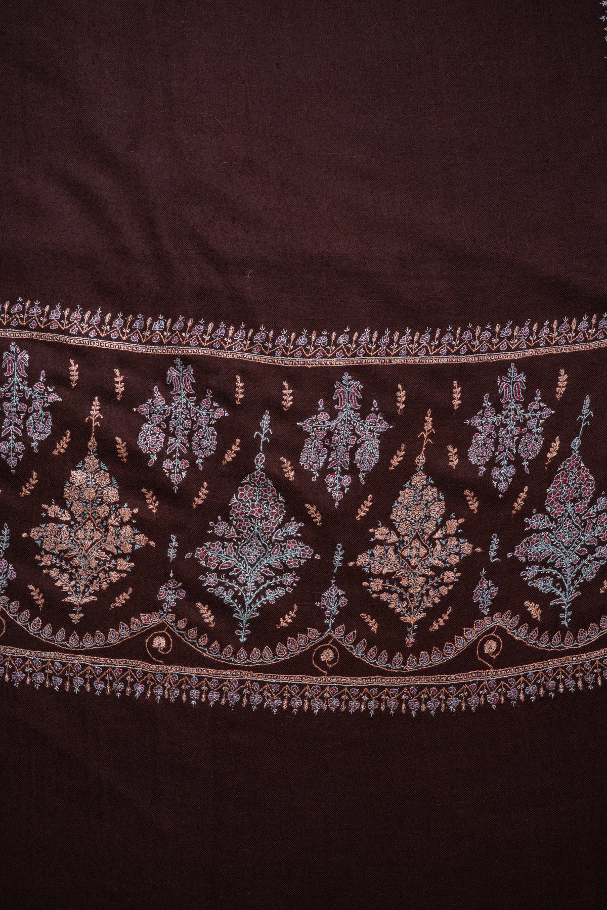 Flat close-up of the brown Pashmina shawl's end panel, with pastel embroidered floral bouquets inside a curved leafy border.
