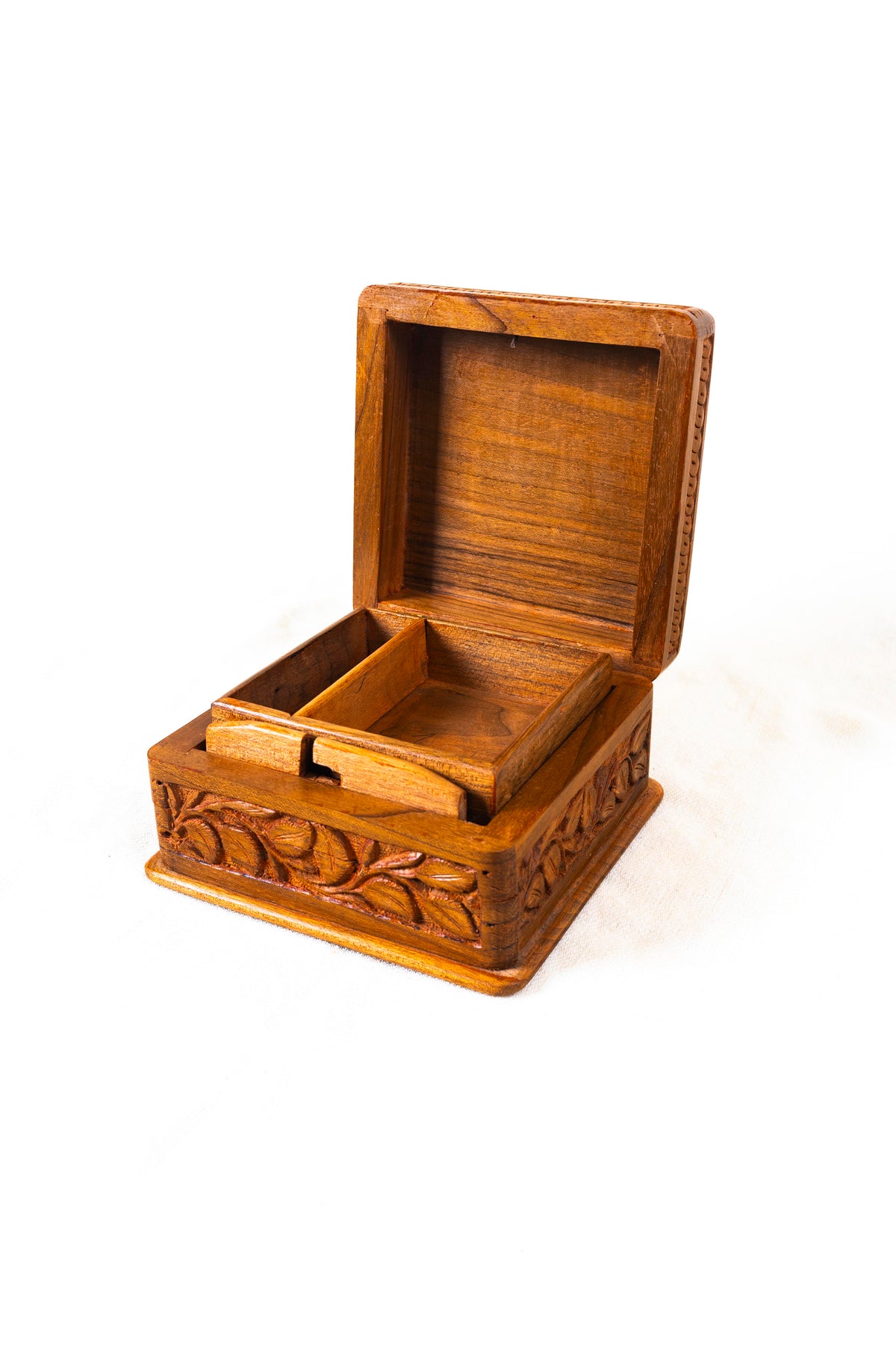 Walnut wood box with its hinged lid open, showing a divided wooden tray and carved exterior panels.