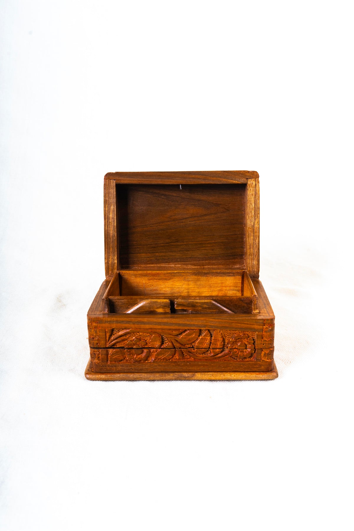 Closer front view of an open walnut wood decorative box with a plain interior and carved flowers and leaves