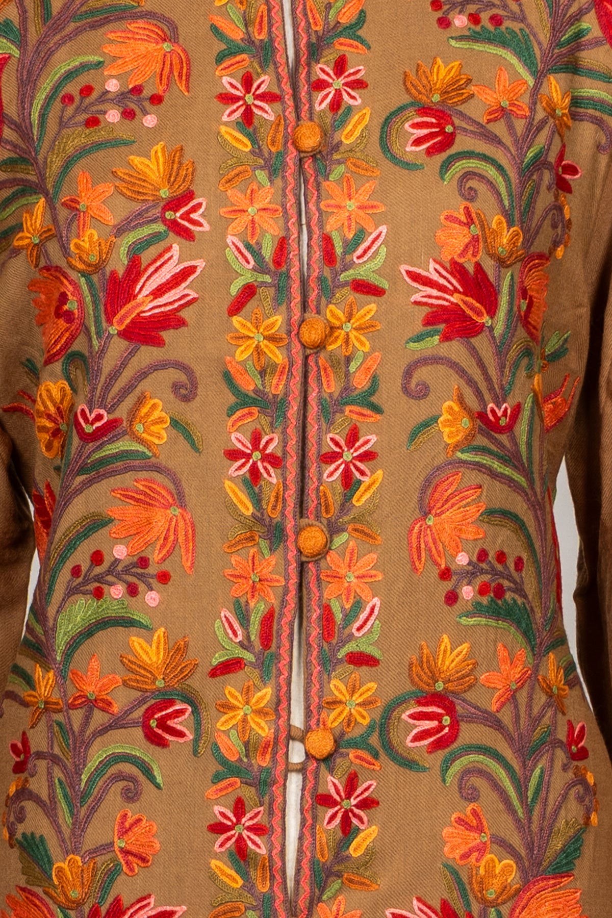 Close-up of the earthy brown Hand Aari jacket’s orange buttons and floral embroidery along the front opening