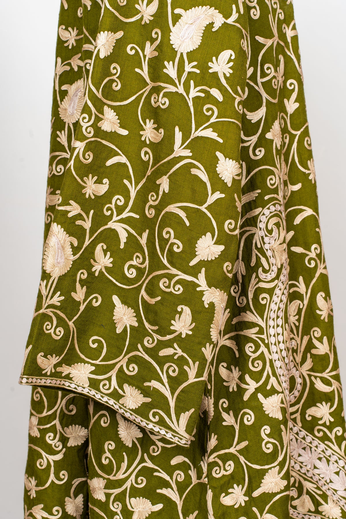 Close view of the olive abaya’s sleeve and narrow cuff edging, with pale floral vines and paisley details