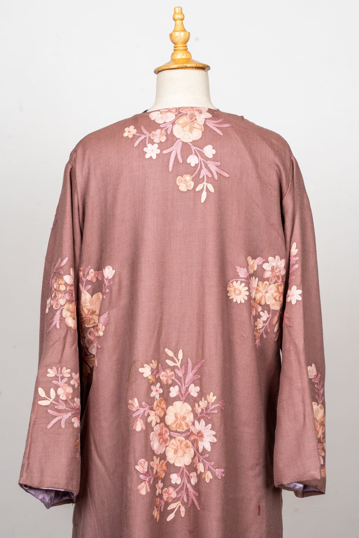 Back of a dusty rose abaya showing scattered pale pink, ivory and peach Aari flower bouquets