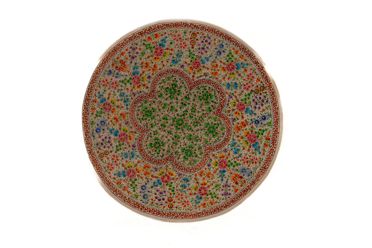 Full round paper mache decorative plate with a green scalloped floral centre, multicoloured flower rings and a narrow rust-red patterned rim