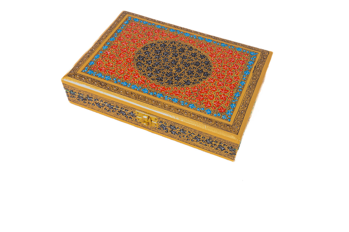 Angled overhead view of the closed Regal Red Grandeur box with fine golden vines, blue borders and a dark central medallion.