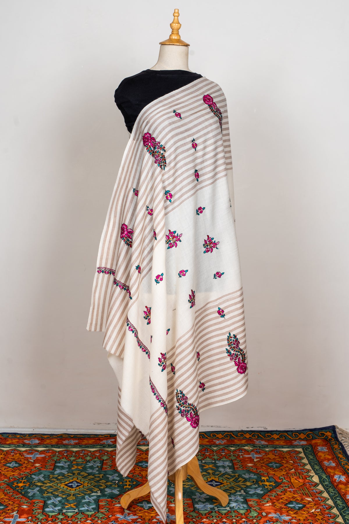 Full view of the striped ivory shawl draped over a mannequin, with scattered pink flowers and larger floral paisleys