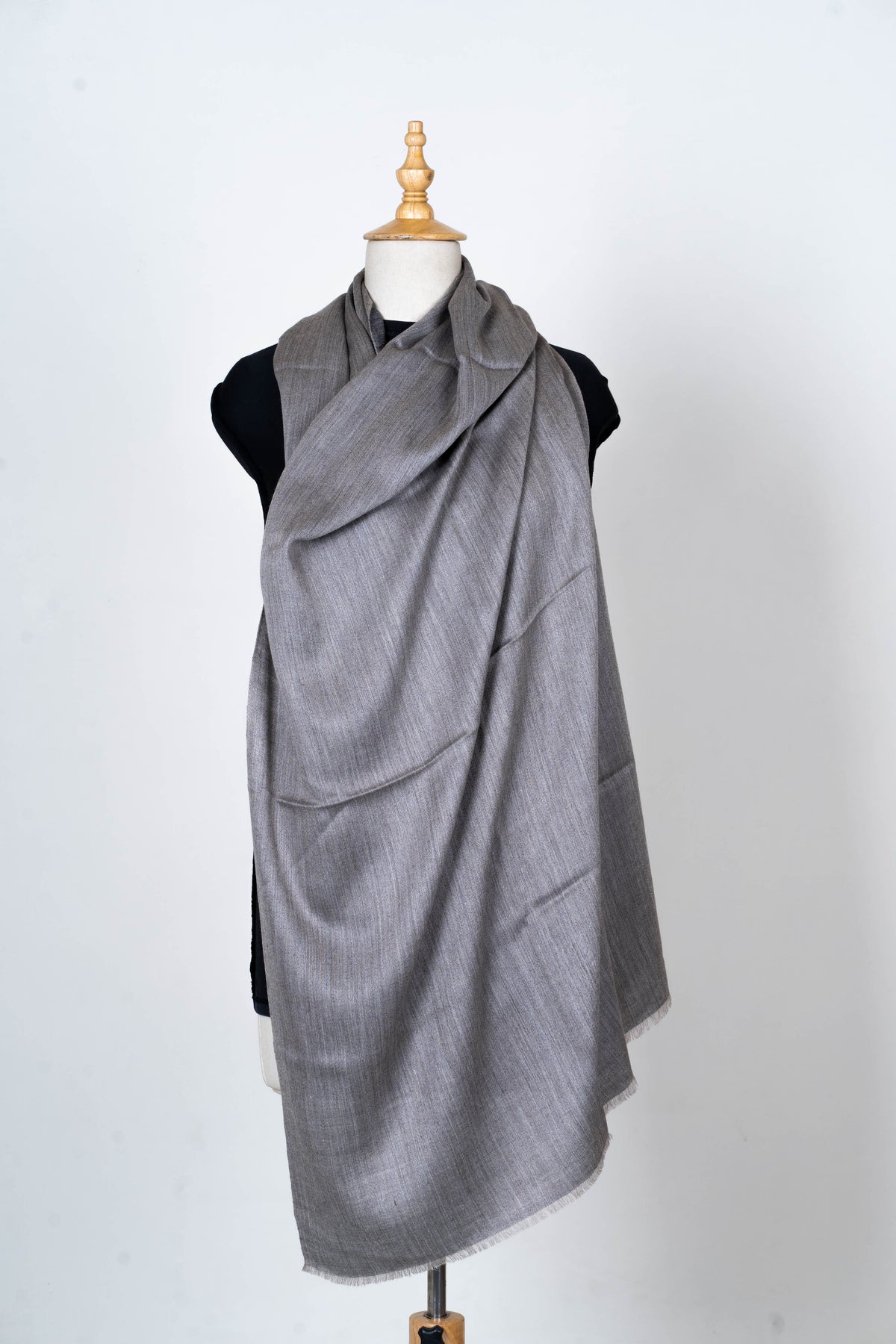 Slate grey side of a reversible Merino wool stole draped broadly across a mannequin's neck and chest