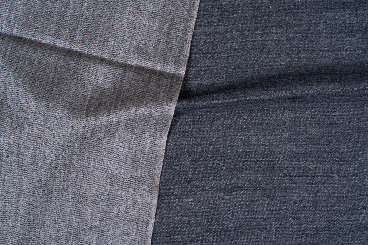 Close-up of the contrasting slate grey and darker steel blue woven surfaces of a folded reversible stole
