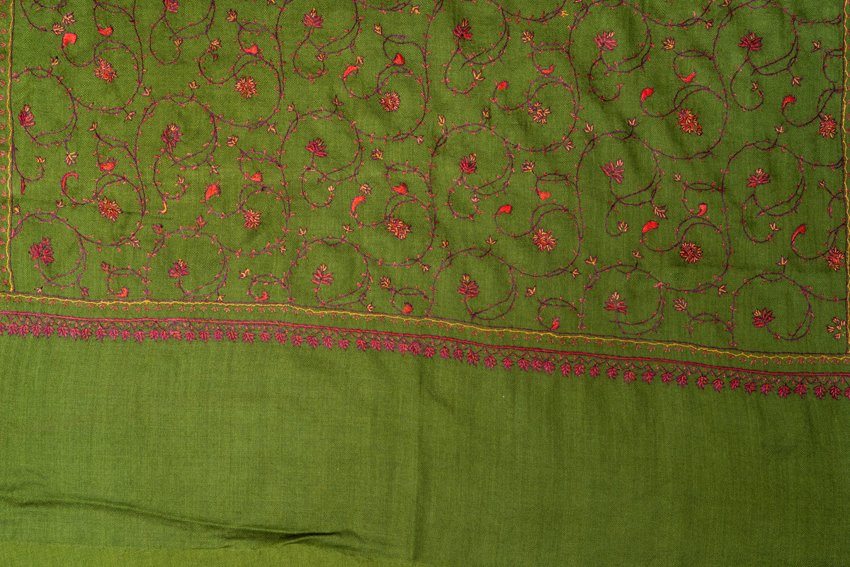 End of an olive-green stole laid flat, with floral vines above narrow gold-toned lines and a row of pink pendant motifs
