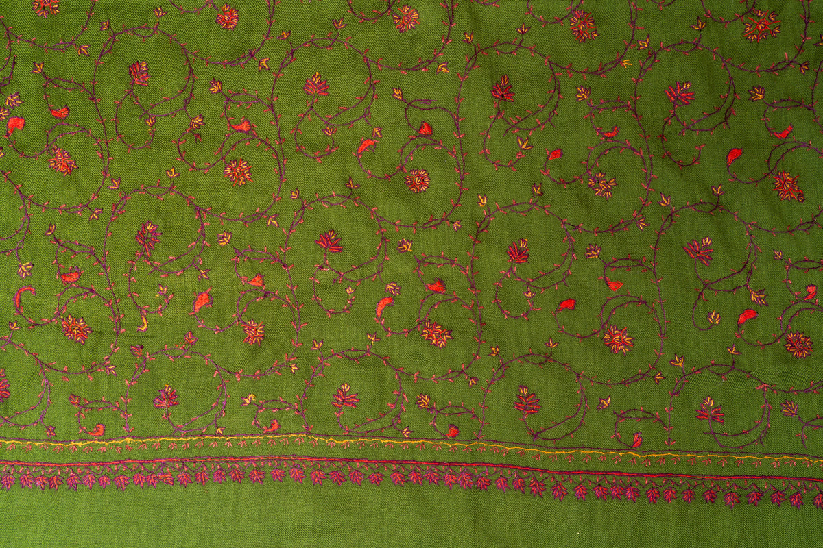 Close-up of red and pink Sozni flowers on maroon curling vines across an olive-green stole above the embroidered end border