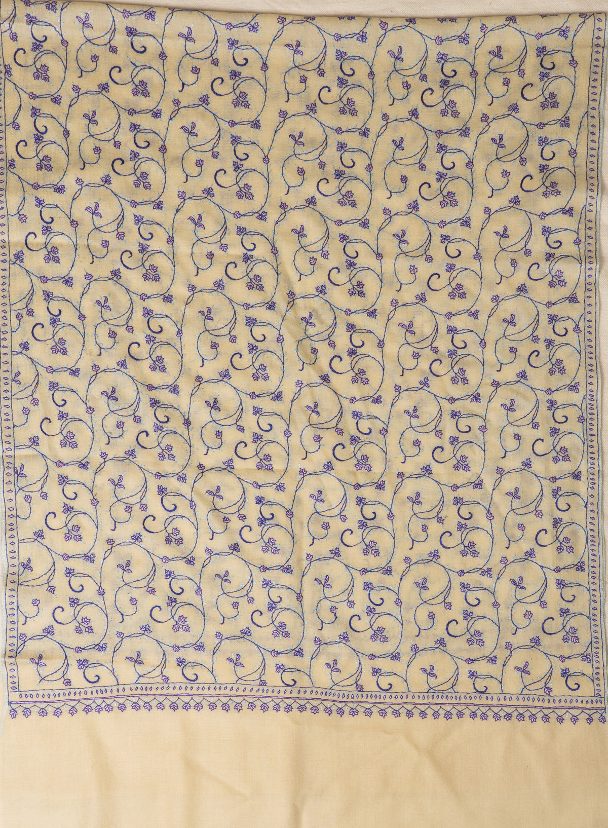 Cream stole laid flat, showing a rectangular field of purple floral vines framed by narrow embroidered borders