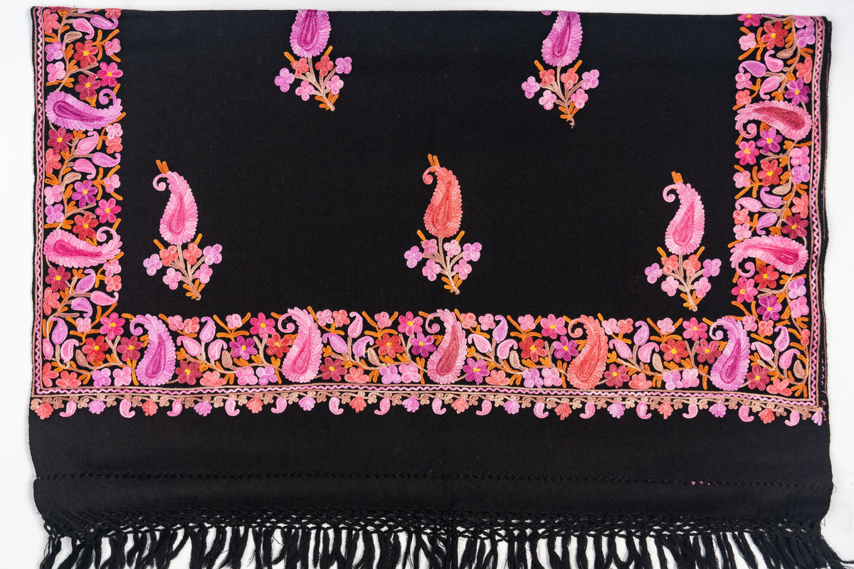 Black stole end laid flat with spaced pink paisley sprigs, a colourful floral border and black fringe