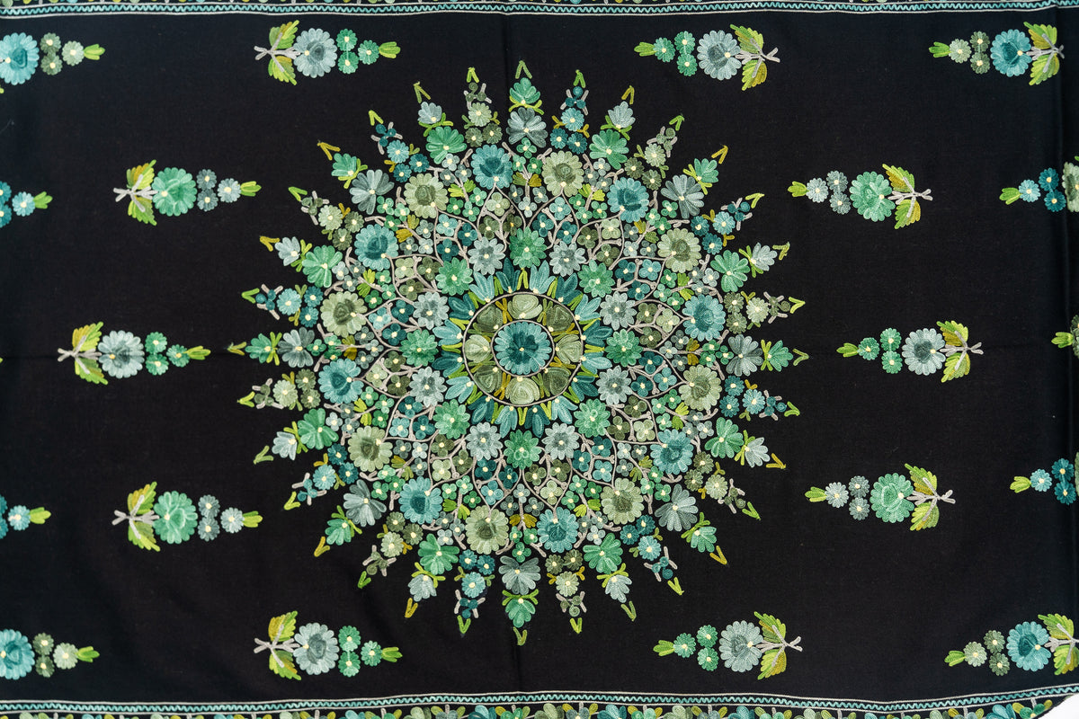 Black stole laid flat with a large circular mint and green floral medallion surrounded by spaced flower sprigs.