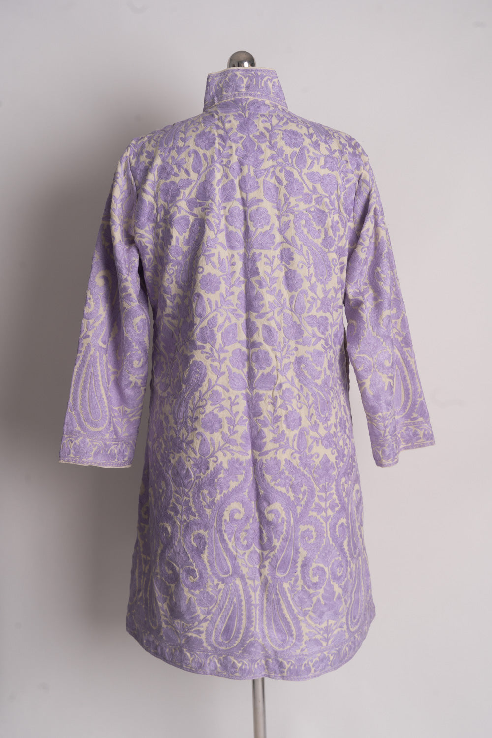 Full back of the cream jacket with lilac floral vines, large paisleys near the hem and embroidered sleeves