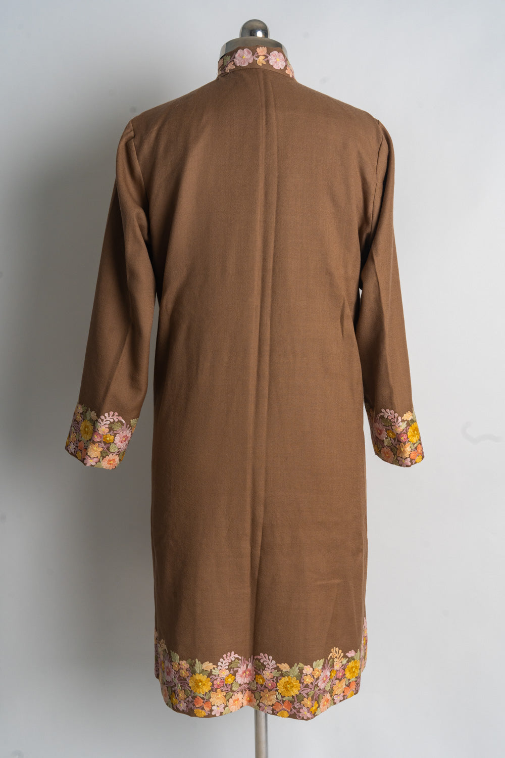 Back of the brown jacket with a plain centre and floral Aari embroidery at the collar, cuffs and hem.