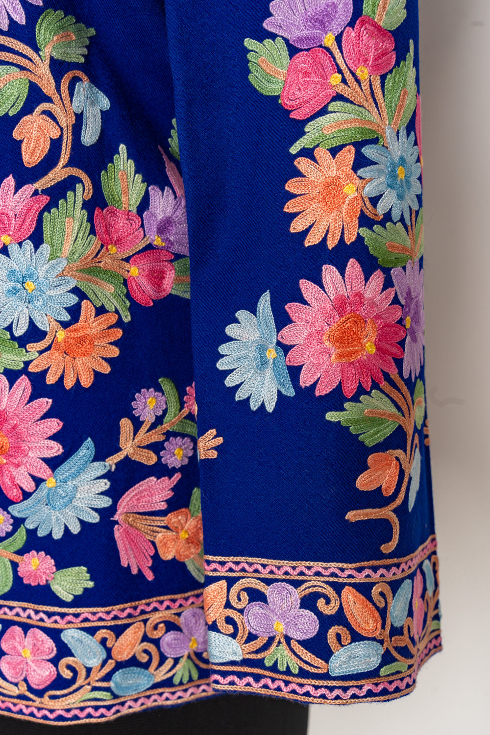Sleeve detail of the blue jacket with bright floral sprays and a narrow pink, purple and green cuff border.