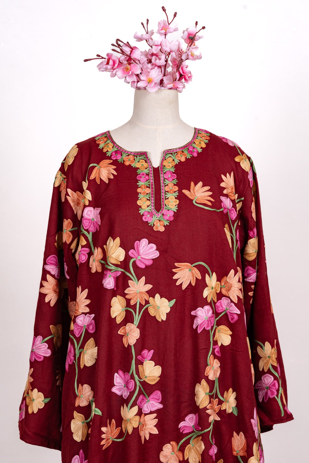 Front view of the crimson abaya with colourful floral Aari embroidery and a flower-bordered slit neckline