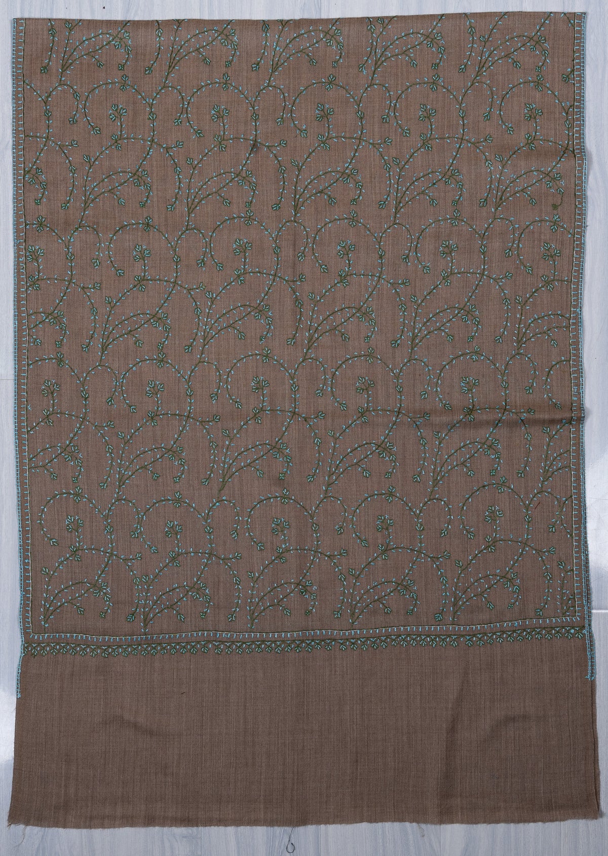 Taupe stole laid flat with flowing teal Sozni vines, narrow embroidered edging and a plain end band
