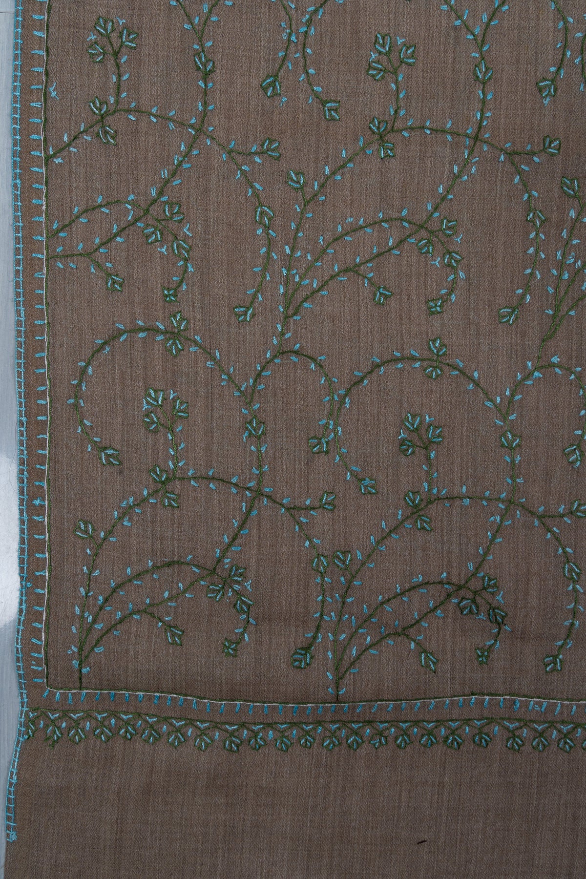 Taupe stole corner with curling teal Sozni vines and a row of small green leaf clusters below the narrow border