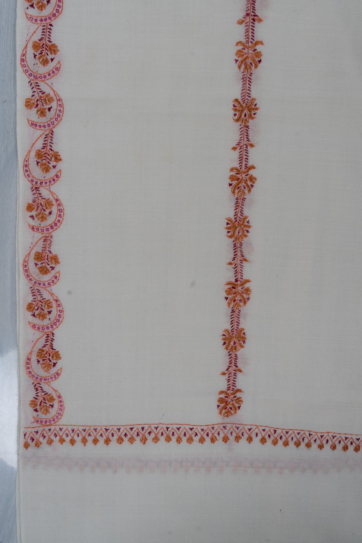Ivory shawl corner with alternating wavy and straight pink and orange Sozni floral stripes above a narrow end border