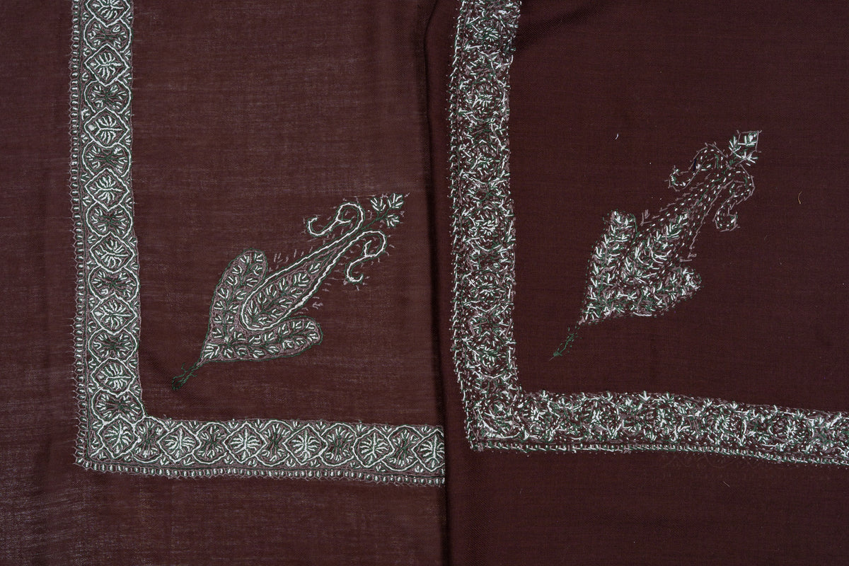 Folded chestnut-brown rumal showing both sides of silver-grey Sozni corner paisleys and geometric floral borders