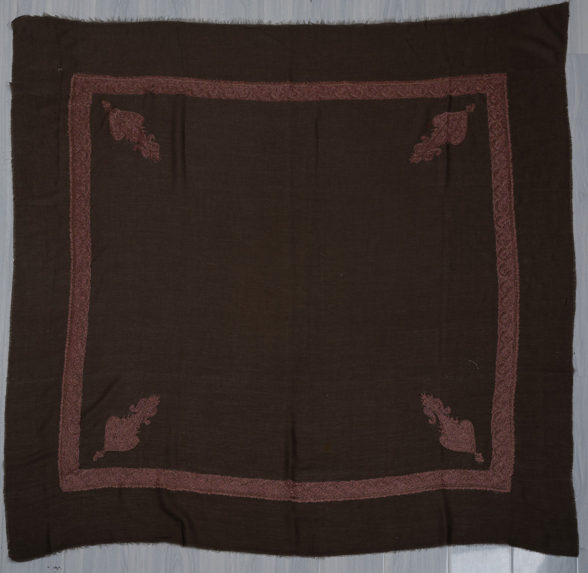 Cocoa-brown square Merino wool rumal laid flat, with a dusty rose embroidered border and four ornate floral corner motifs