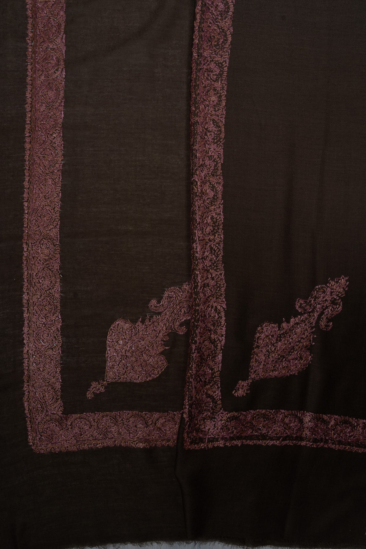 Overlapping cocoa-brown rumal corners, showing both sides of dusty rose Sozni floral motifs and narrow borders