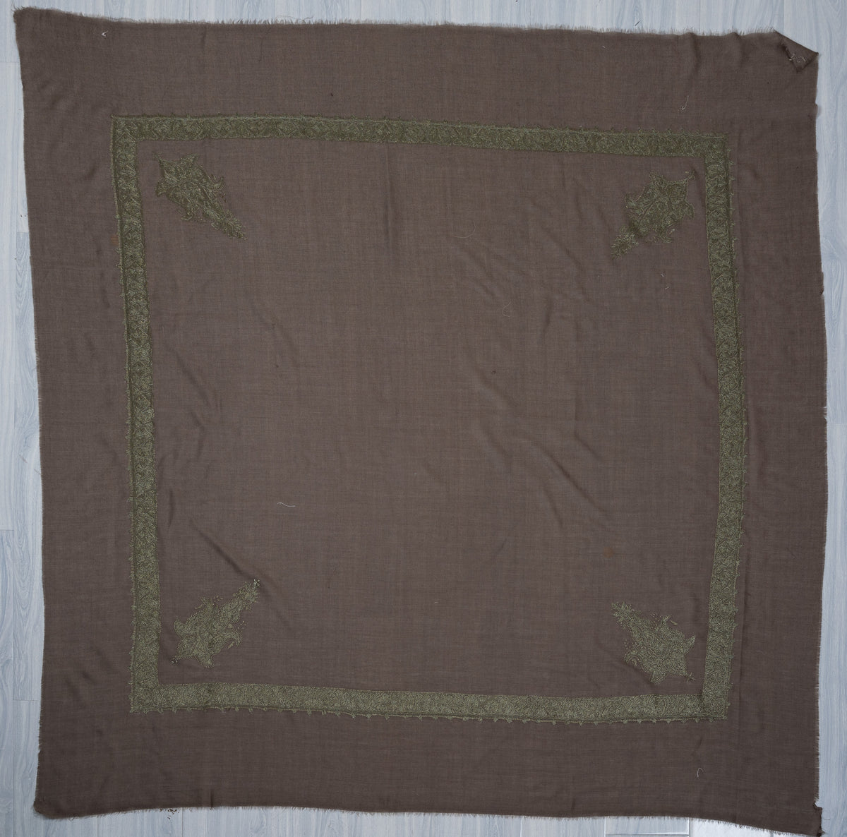Taupe-grey square Merino wool rumal laid flat, with a sage-green embroidered border and four ornate floral corner motifs