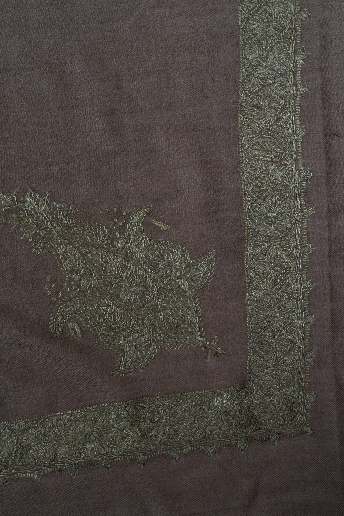 Taupe-grey rumal corner with an ornate sage-green Sozni floral motif beside a narrow leafy border