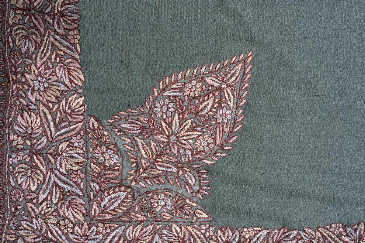 Detail of the large leaf-shaped corner motif filled with cream and brown flowers on sage-green fabric