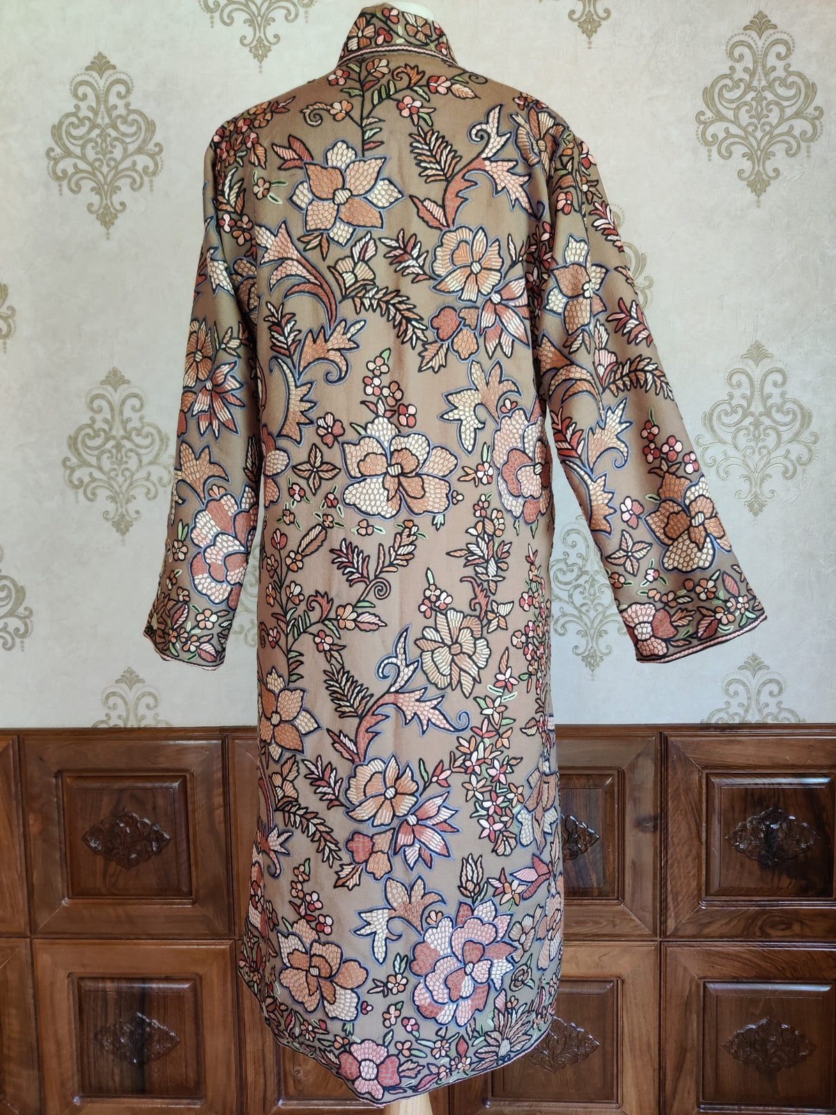 Back view of the beige wool jacket, showing large pastel flowers and leafy Hand Aari embroidery