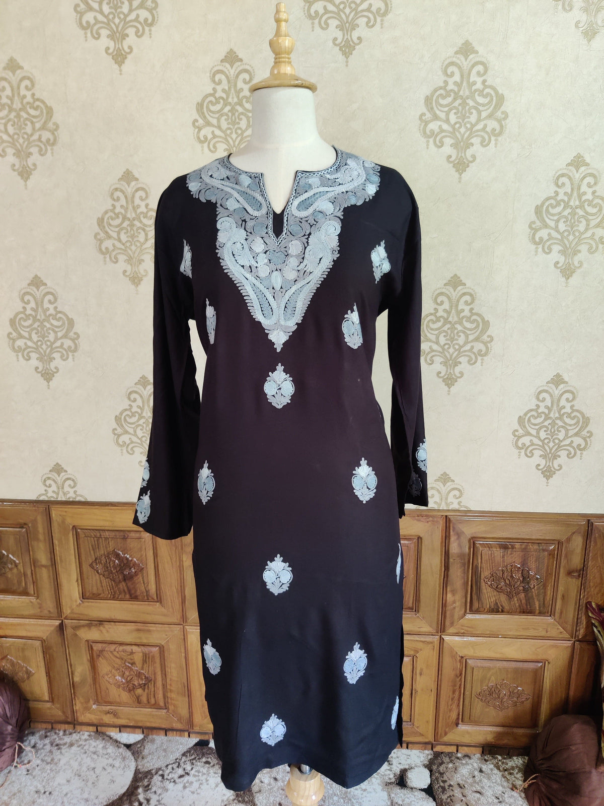 Full front of the black kurti on a mannequin with a large silver-grey Aari neckline panel and small floral motifs across the body.