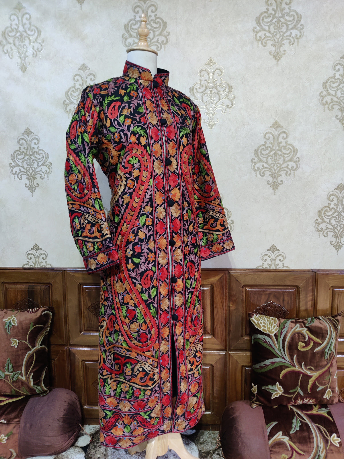 Full front of the black Aari jacket on a mannequin, with long red-edged floral paisleys and dense embroidered hem bands.